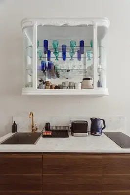 a kitchen with a sink and a shelf with glasses at Old Town Apartment Kraków in Kraków