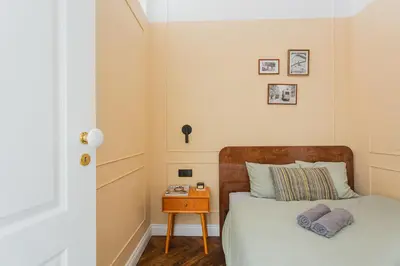 a small bedroom with a bed and a night stand at Old Town Apartment Kraków in Kraków