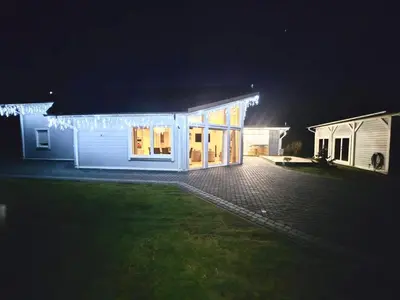 a house with christmas lights on it at night at Babiogórska Perełka w skandynawskim stylu z sauną i kominkiem in Jordanów