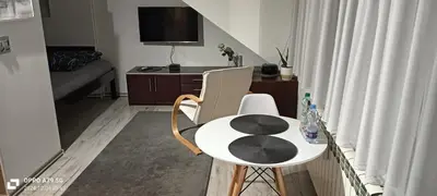 a small white table and chair in a room at Apartament Skawina in Skawina