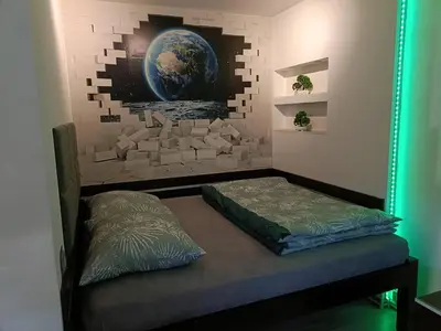 a bed in a room with a wall with a mirror at Apartament Skawina in Skawina