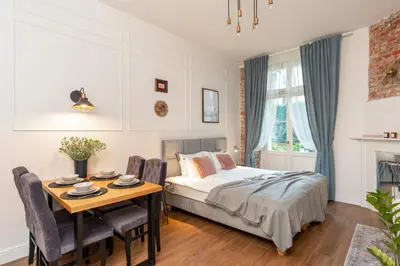 a bedroom with a bed and a table with chairs at Cozy Apartment in Old Town in Kraków