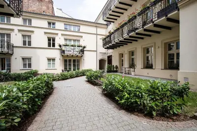 a walkway in front of a building with plants at Cozy Apartment in Old Town in Kraków