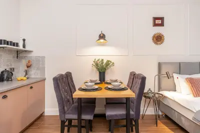 a kitchen and dining room with a table and chairs at Cozy Apartment in Old Town in Kraków
