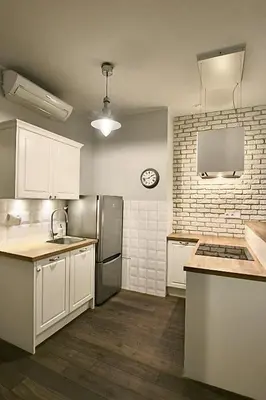 a kitchen with white cabinets and a stainless steel refrigerator at Old Town Apartment in Kraków