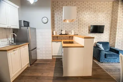 a kitchen with white cabinets and a blue couch at Old Town Apartment in Kraków