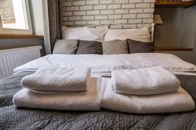 a bed with white towels on top of it at Old Town Apartment in Kraków