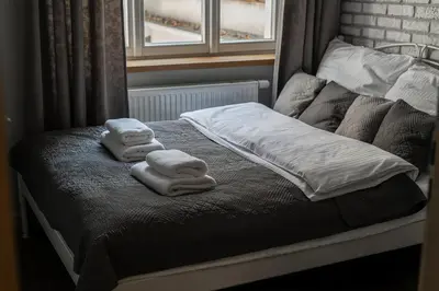 a bed with two towels on it with a window at Old Town Apartment in Kraków