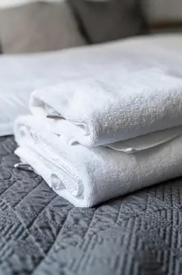 a stack of white towels sitting on a bed at Old Town Apartment in Kraków