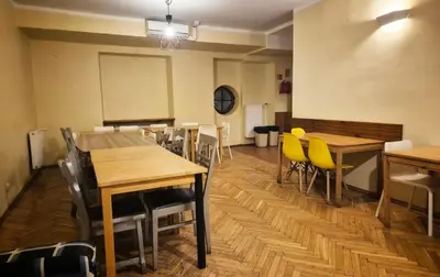 a dining room with wooden tables and yellow chairs at 50 People Bis Apartment in Kraków