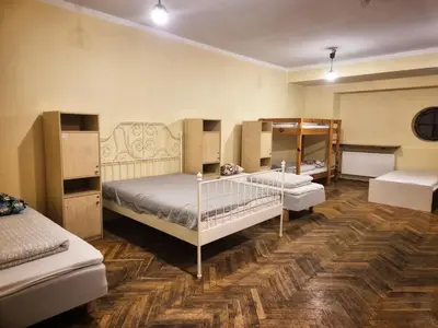 a room with four bunk beds and a table at 50 People Bis Apartment in Kraków