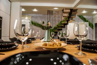 a table with wine glasses and a plate of food at KROSNA92 in Krosna