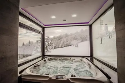 a jacuzzi tub in a room with windows at KROSNA92 in Krosna