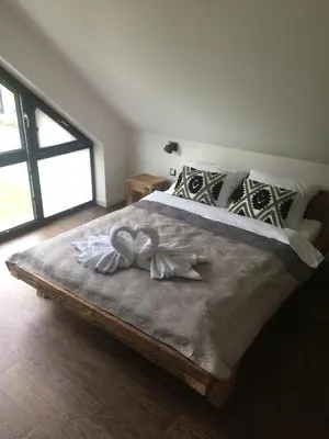 a bedroom with a bed with white towels on it at Domy Pod Babią in Zawoja