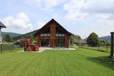 a house with a green lawn in front of it at Domy Pod Babią in Zawoja