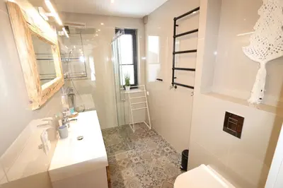 a white bathroom with a sink and a shower at Domy Pod Babią in Zawoja