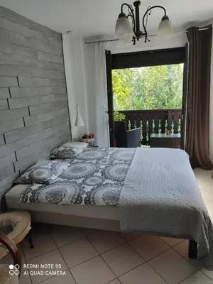 a bedroom with a bed and a window with a view at Pokój w domu z dużym ogrodem in Kraków