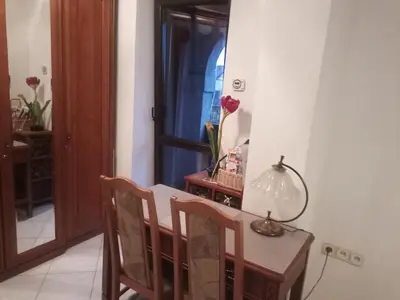 a dining room with a table and chairs and a lamp at Pokój w domu z dużym ogrodem in Kraków