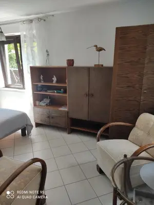 a living room with a couch a chair and a cabinet at Pokój w domu z dużym ogrodem in Kraków