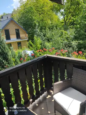 a balcony with a bench and a garden at Pokój w domu z dużym ogrodem in Kraków