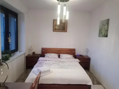 a bedroom with a bed and a table and a window at Pokój w domu z dużym ogrodem in Kraków