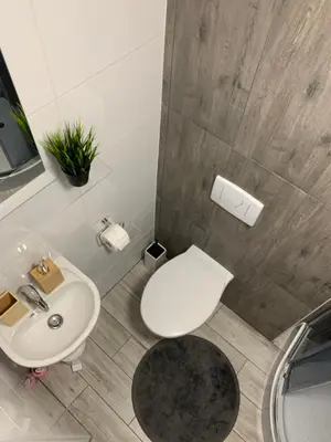 a bathroom with a white toilet and a sink at Discover Cracow APARThostel in Kraków