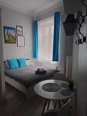 a small bedroom with a bed and a table at Discover Cracow APARThostel in Kraków
