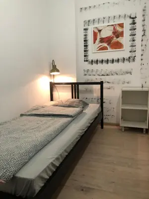 a bedroom with a bed and a lamp on a wall at NR 4 in Kraków