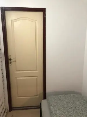 a white door with a wooden frame next to a bed at NR 4 in Kraków