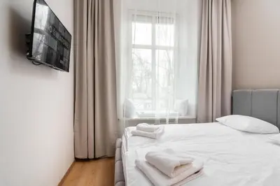 a bedroom with a white bed with towels on it at Modern Centrally Located Apartments - by Upstairs in Kraków