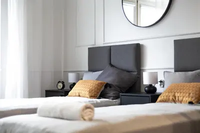 a bedroom with two beds and a mirror on the wall at Studio Kolberga Kraków in Kraków