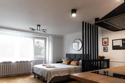 a bedroom with a bed and a large window at Studio Kolberga Kraków in Kraków