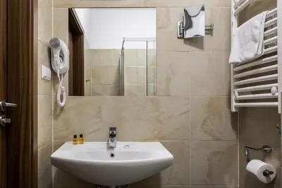 a bathroom with a sink and a mirror at G12 Aparthotel in Kraków