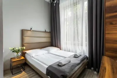 a bed in a room with a large window at G12 Aparthotel in Kraków