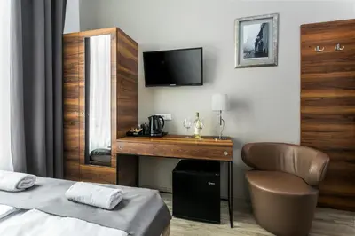 a bedroom with a desk and a bed and a television at G12 Aparthotel in Kraków