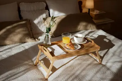 a coffee table with a breakfast on a bed at ZENDA - Przytulny apartament w zacisznym miejscu in Wieprz