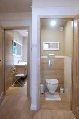 a bathroom with a toilet and a sink at ZENDA - Przytulny apartament w zacisznym miejscu in Wieprz