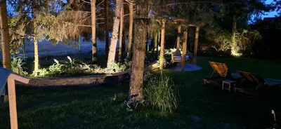 a yard with two chairs and trees at night at ZENDA - Przytulny apartament w zacisznym miejscu in Wieprz