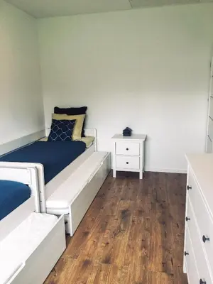 a bedroom with a white bed and a wooden floor at DOMEK U MARKA Zator in Przeciszów