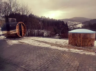 a barrel and a trash can sitting on a brick road at Sarnie wzgórze Sucha Beskidzka sauna jacuzzi in Kuków