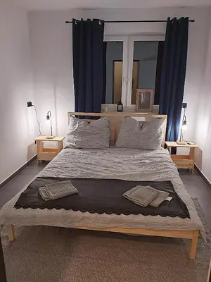 a bedroom with a large bed with blue curtains at Sarnie wzgórze Sucha Beskidzka sauna jacuzzi in Kuków