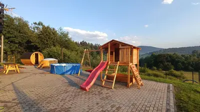 a play set with a slide and a playground at Sarnie wzgórze Sucha Beskidzka sauna jacuzzi in Kuków