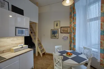 a kitchen and dining room with a table and chairs at Stylish Apartment Kraków - Old Town in Kraków
