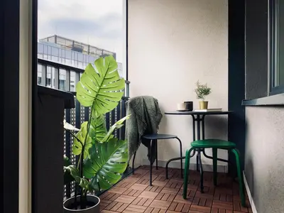a balcony with two chairs and a table and a plant at Apartment next to Cracow Eye, Vistula Boulevards in Kraków