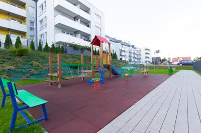 a playground with colorful chairs and a swing at Lenzo Apartments Wieliczka in Wieliczka