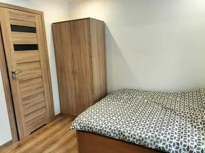 a bedroom with a bed and a wooden cabinet at Zielony Zakątek in Złota