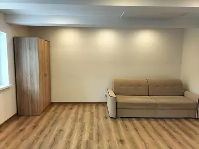 a living room with a couch and a wooden floor at Zielony Zakątek in Złota