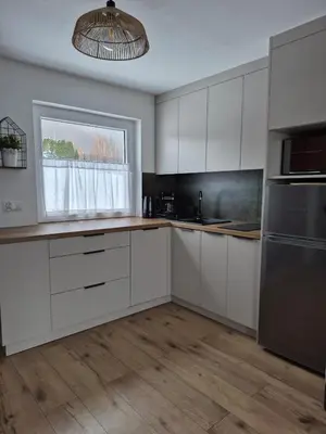 a kitchen with white cabinets and stainless steel appliances at JAWORNICA HOUSE domek z pięknym widokiem in Targanice