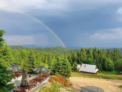 a rainbow in the sky over a garden with a house at Domek w Górach- Bacówka u Dudka in Nowy Targ