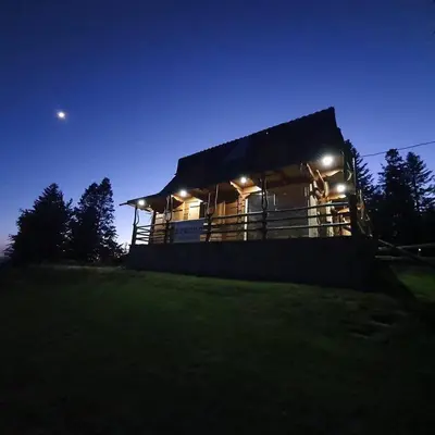 a building with lights on in a field at night at Domek w Górach- Bacówka u Dudka in Nowy Targ